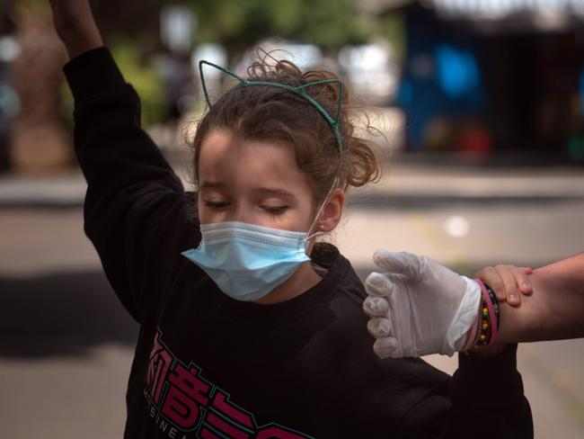 A girl holds her mother's hand as she walks the street in Santa Cruz de tenerife on April 26, 2020 during a national lockdown to prevent the spread of the COVID-19 disease. - After six weeks stuck at home, Spain's children were being allowed out today to run, play or go for a walk as the government eased one of the world's toughest coronavirus lockdowns. Spain is one of the hardest hit countries, with a death toll running a more than 23,000 to put it behind only the United States and Italy despite stringent restrictions imposed from March 14, including keeping all children indoors. Today, with their scooters, tricycles or in prams, the children accompanied by their parents came out onto largely deserted streets. (Photo by DESIREE MARTIN / AFP)