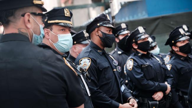 Members of the NYPD congregate in Times Square near a police precinct for a security briefing as security throughout the city is increased ahead of the verdict.