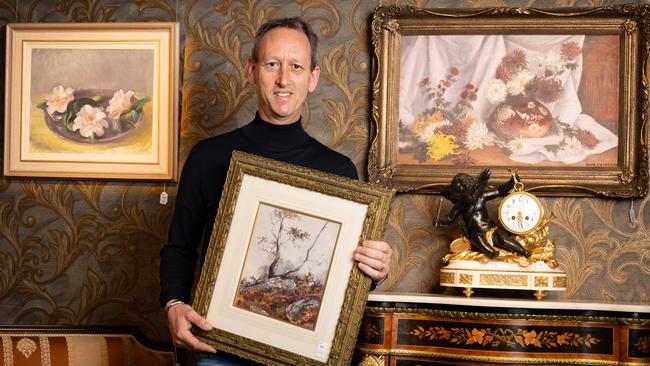 Auctioneer Marc du Plessis with paintings for auction by Sir Hans Heysen, as well as one by Nora Heysen (left). Picture: NCA NewsWire / Morgan Sette