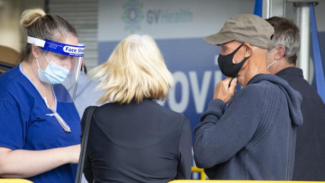 A health worker talks to people in the queues at the Goulban Valley Health Hospital in Shepparton. Picture: Sarah Matray