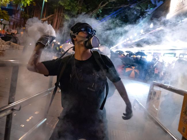 A protester throws back tear gas fired by riot police in the Cheung Sha Wan area on August 11. Picture: Billy H.C. Kwok/Getty Images