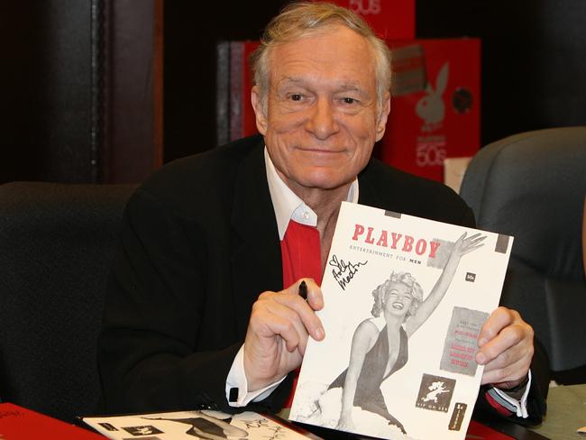 Hugh Hefner signing copies of the Playboy calendar. Picture: Supplied