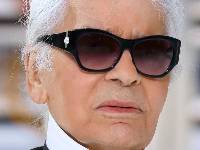 German fashion designer Karl Lagerfeld acknowledges the audience at the end of the Chanel 2017 Spring/Summer ready-to-wear collection fashion show on October 4, 2016 in Paris. / AFP PHOTO / PATRICK KOVARIK