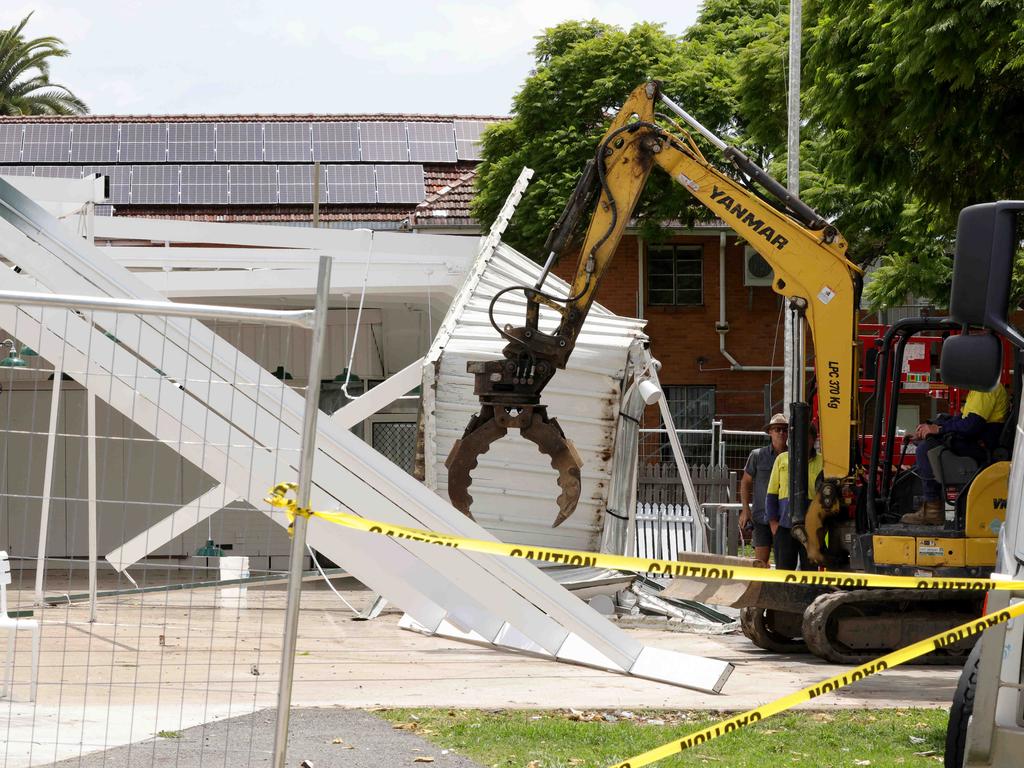 Workers on site after the Officers Mess lost its roof in Friday’s intense storm. Picture: Steve Pohlner