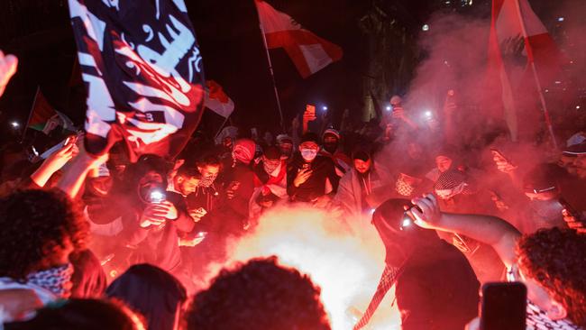 Pro-Palestine supporters light flares at the Sydney Opera House on Monday night. Picture: David Swift