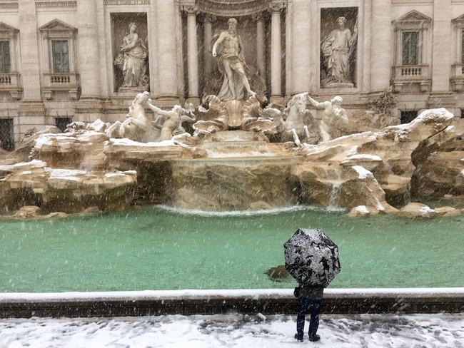 A man looks at the Trevi Fountain during a snowfall, in Rome, Monday, Feb. 26, 2018. Romans have awoken to a rare snowfall, after an Arctic storm passing over much of Europe dumped enough snow to force schools to close and public transport to reduce services. Picture: AP