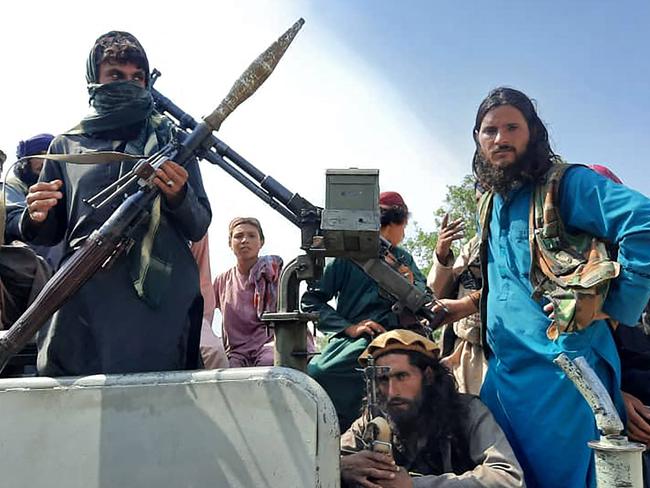 Taliban fighters sit over a vehicle on a street in Laghman province. Picture: AFP