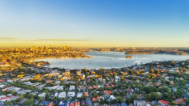 Wealthy Eastern suburbs of Sydney city around Harbour in aerial view with soft morning light and blue sky. Australian housing generic