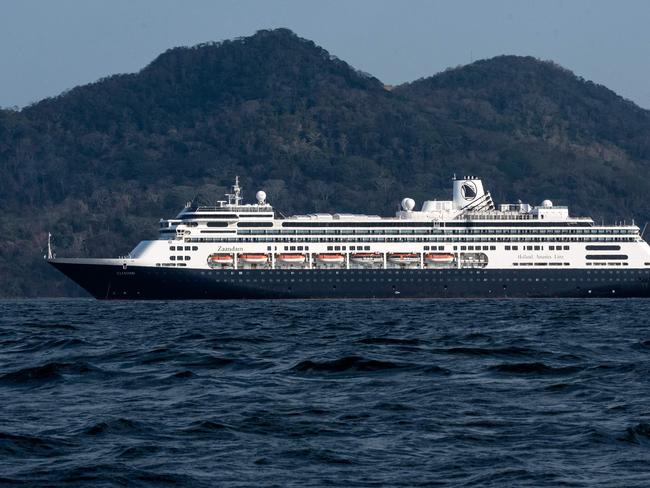 View of Holland America's cruise ship Zaandam as it entered the Panama City bay to be assisted by the Rotterdam cruise ship with supplies, personnel and COVID-19 testing devices, eight milles off the coast of Panama City, on March 27, 2020. - Four passengers have died aboard a cruise ship carrying scores of people with flu-like symptoms that has been stranded off the Pacific coast of South America for several days, the liner company said Friday. The Zaandam, with 1,800 passengers on board, is currently in Panama's territorial waters, having been prevented from docking in several countries due to coronavirus fears. (Photo by Luis Acosta / AFP)