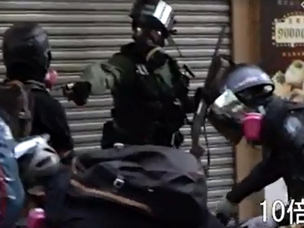 A Hong Kong policeman, centre, shooting a protester, left, during clashes in the Tsuen Wan district in Hong Kong. Picture: Campus TV, HKUSU/AFP