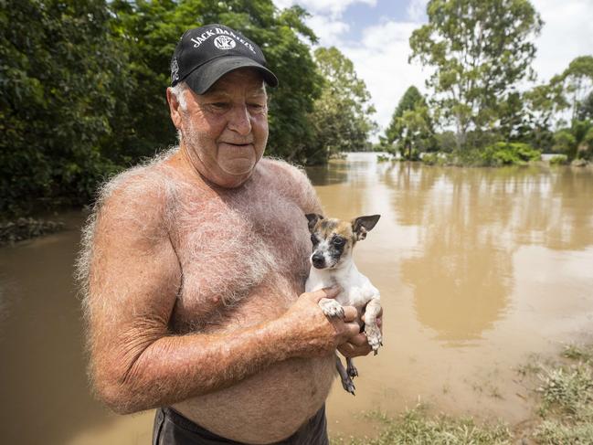 65 year old Maryborough resident Greg Sears with his dog Tadpole in his front yard as his house on Bazaar street remains underwater after being inundated by floodwaters on Saturday. Picture Lachie Millard