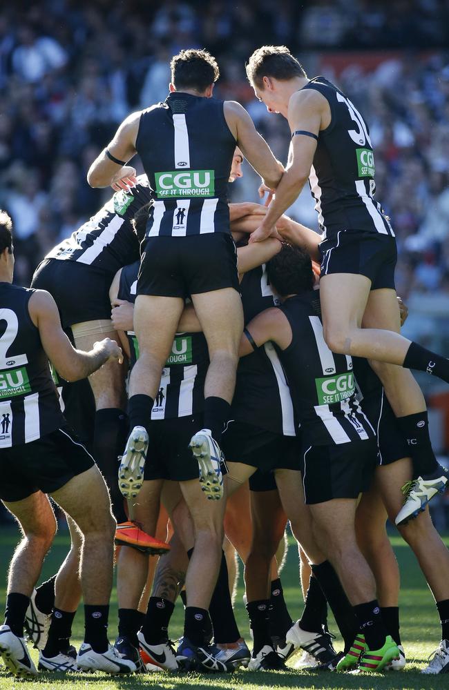 Mason Cox is swamped by Pies. Picture: George Salpigtidis