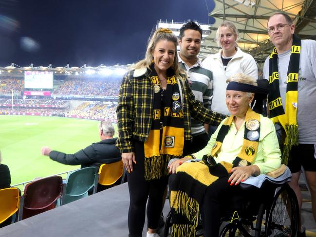 MUST HOLD WEEKEND PAPERS -  Leanne Sklavenitis, mum in the wheelchair, daughter Maree Sklavenitis (long hair), husband Steve Spangenberg (grey T), carer Talah Hilton (white top), carer Sanjog Giri (stripes), on the Wheel Chair viewing area, Access issues at the Gabba Stadium, Lions vs Richmond at the Gabba, on Saturday 18th May 2024 - Photo Steve Pohlner