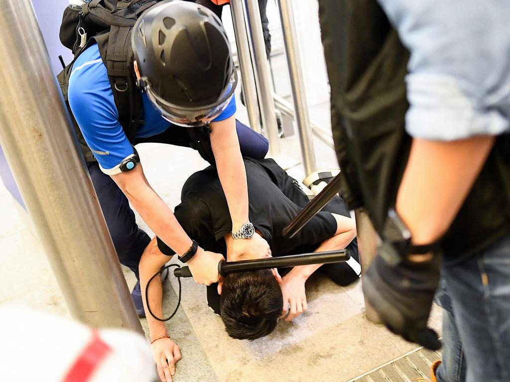 Police detain a pre-democracy protester at Hong Kong's international airport. Picture: AFP