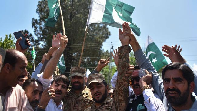 Forest department employees gesture with army personnel at a check post to express solidarity with Pakistan's armed forces during a rally in Muzaffarabad. Picture: Sajjad Qayyum / AFP