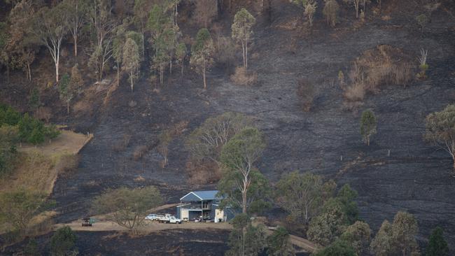 A burnt out paddock surrounds a house near Lamington National Park Road, Canungra.