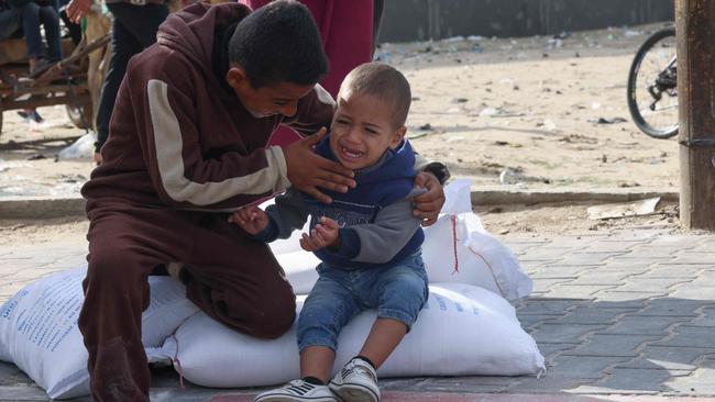 Palestinians receive bags of flour at the United Nations Relief and Works Agency for Palestine Refugees (UNRWA) distribution centre in the Rafah refugee camp in the southern Gaza Strip on November 21, 2023, amid ongoing battles between Israel and the Palestinian Hamas movement. Picture: AFP