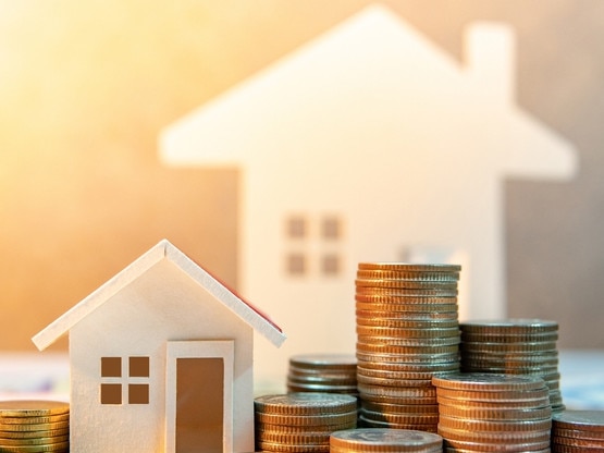 Real estate or property investment. Home mortgage loan rate. Saving money for retirement concept. Coin stack on international banknotes with house model on table. Business growth background Picture: iStock