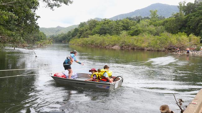 Goldsborough resident Sonya Bielek pulls a small boat across the Mulgrave River to complete the daily school run after flood waters washed the Fisheries Bridge away on December 18. Picture: Peter Carruthers