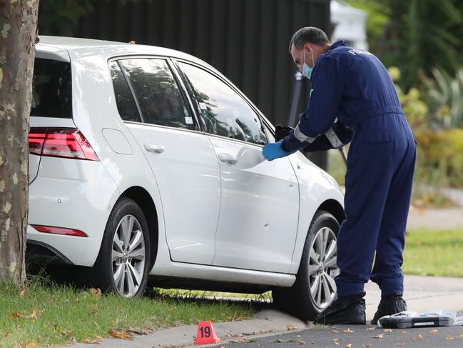 Forensic investigators inspect the Volkswagen. Picture: David Crosling