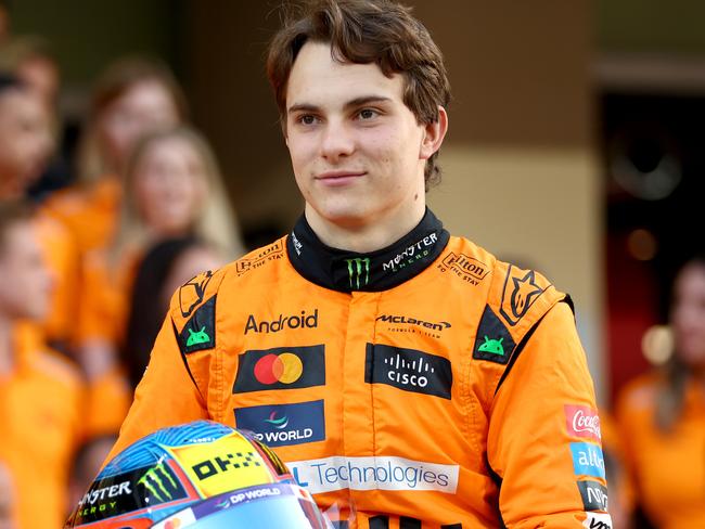 ABU DHABI, UNITED ARAB EMIRATES - DECEMBER 05: Oscar Piastri of Australia and McLaren looks on at the McLaren team photo in the Pitlane during previews ahead of the F1 Grand Prix of Abu Dhabi at Yas Marina Circuit on December 05, 2024 in Abu Dhabi, United Arab Emirates. (Photo by Bryn Lennon - Formula 1/Formula 1 via Getty Images)