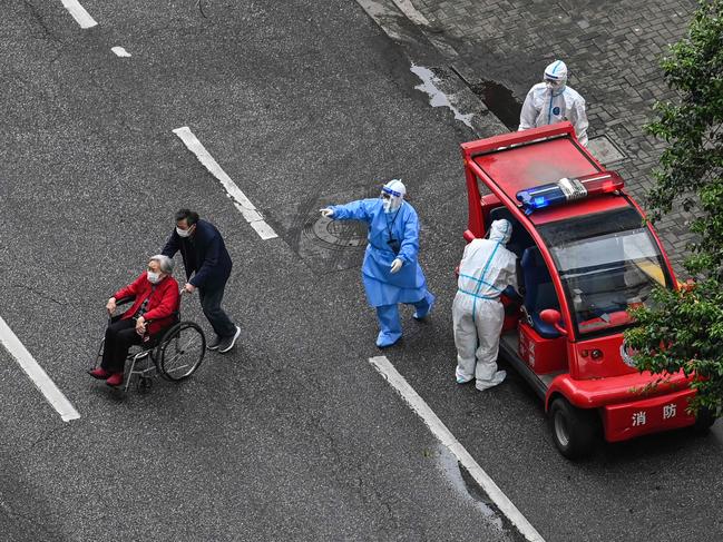 An officer wearing personal protective equipment (PPE) gestures to residents on a street during a coronavirus lockdown in the Jing'an district in Shanghai. Picture: AFP