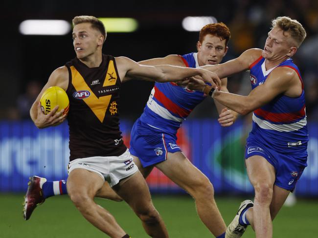 MELBOURNE , AUSTRALIA. May 4, 2024.  AFL Round 8. . Western Bulldogs vs Hawthorn at Marvel Stadium.   Harry Morrison of the Hawks  fends off Bulldog Adam Treloar during the 1st qtr.    . Pic: Michael Klein