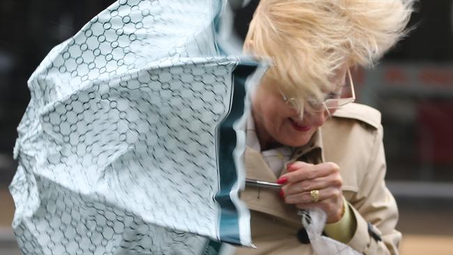 A sever storm still lashing Sydney has caused major damage to the electrical system .a wind blown woman in Bondi .pic john grainger