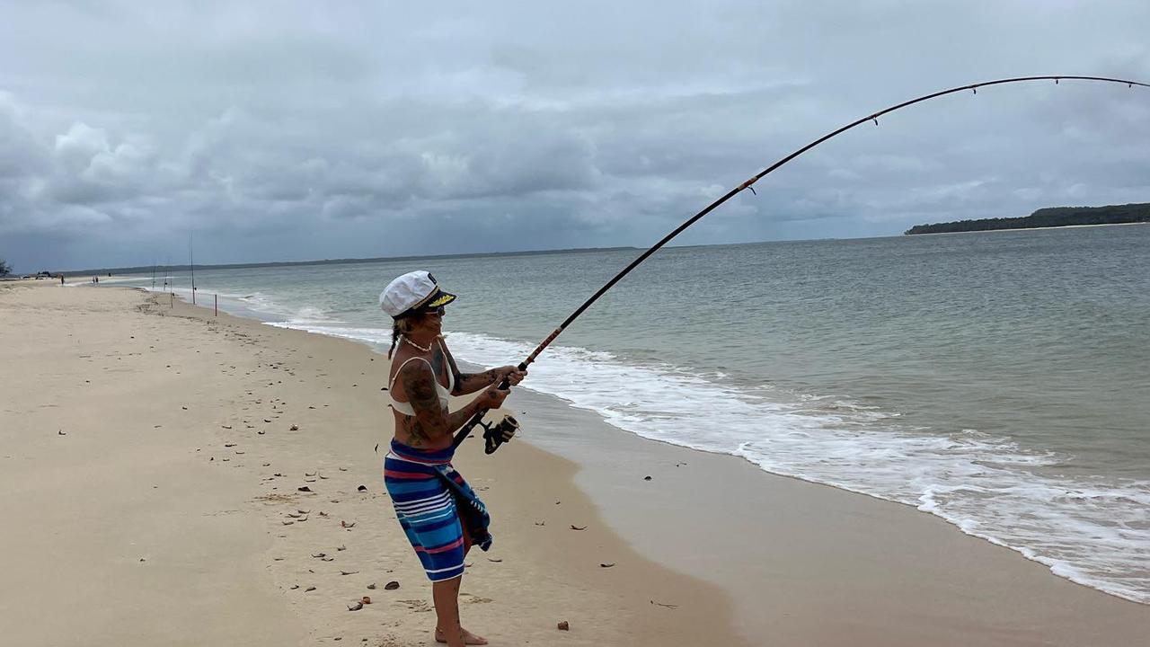 Sammie Holland works to reel in the 20kg trevally at Inskip Point.