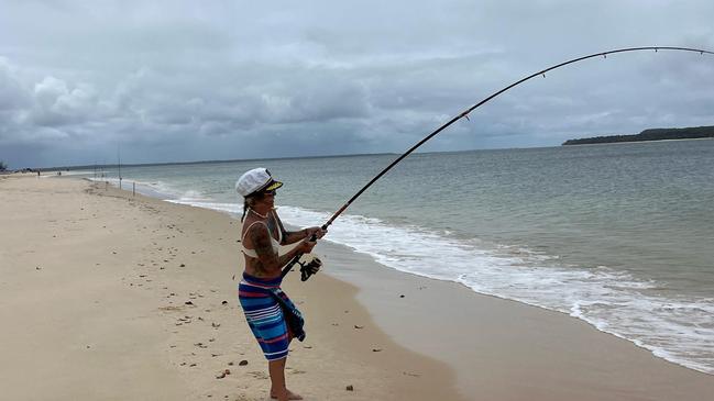 Sammie Holland works to reel in the 20kg trevally at Inskip Point.