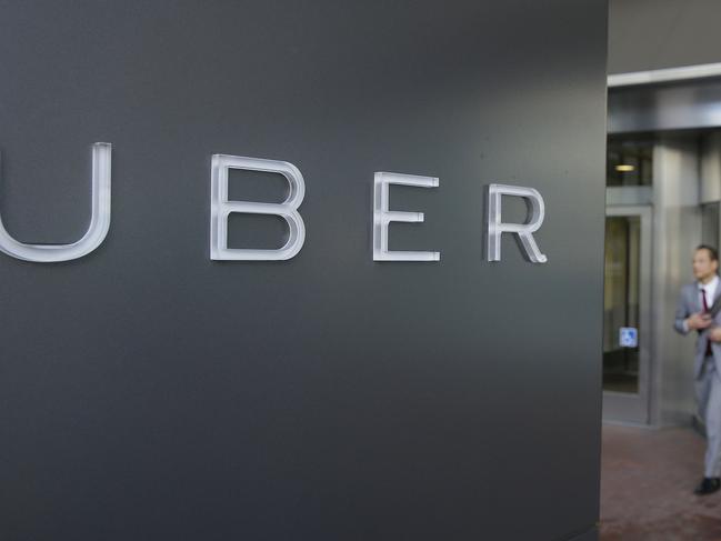 FILE - In this photo taken Tuesday, Dec. 16, 2014, a man leaves the headquarters of Uber in San Francisco. In rulings filed Wednesday, March 11, 2015, two San Francisco federal judges said juries will have to decide whether former drivers for Uber and Lyft were independent contractors, or employees of the ride-hailing companies with all of the protections and benefits the state affords regular workers. The rulings have potentially expensive ramifications for Uber and Lyft. (AP Photo/Eric Risberg, File)