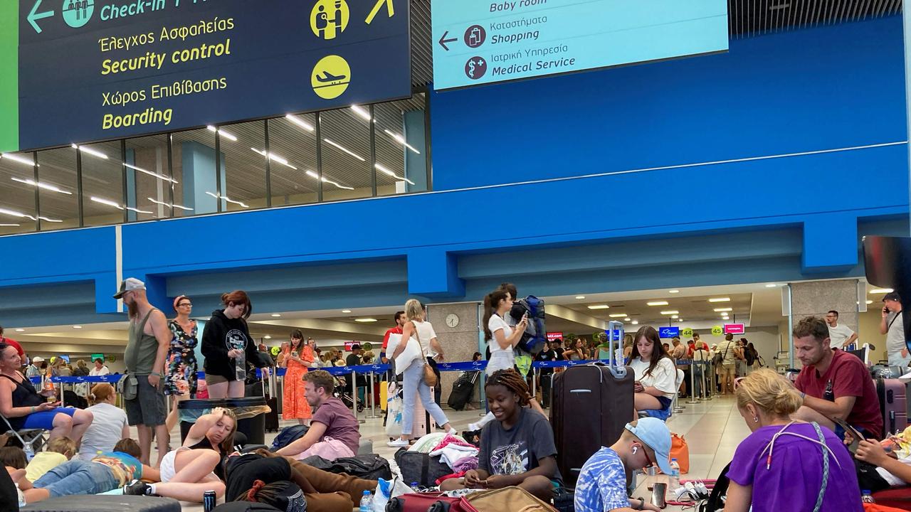 Tourists wait in the airport's departure hall as evacuations continue in Rhodes. (Photo by Will VASSILOPOULOS / AFP)