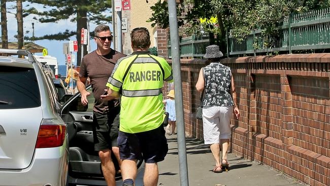 A council ranger issues a ticket in Manly.