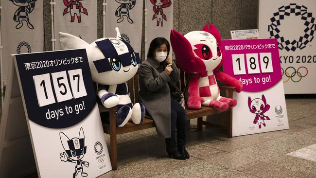 A woman poses with the mascots of the Tokyo 2020 Olympics and Paralympics in Tokyo on February 18. Picture: AP Photo/Jae C. Hong, File