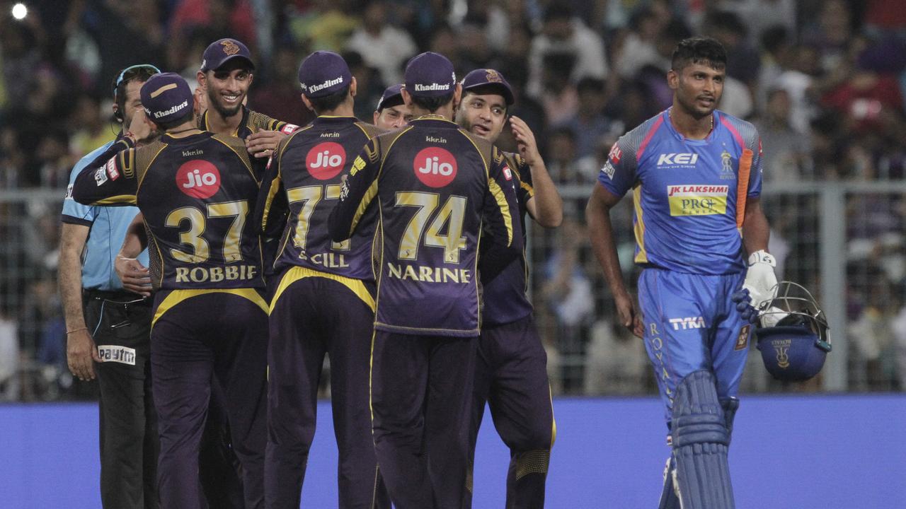 Kolkata Knight Riders' players celebrate their win over Rajasthan Royals by twenty fine runs, as Krishnappa Gowtham of Rajasthan Royals walks off the field