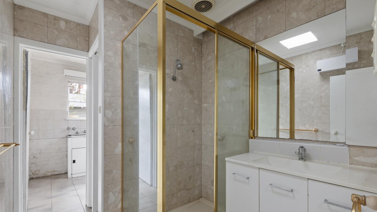 Ready for an upgrade — the home’s single bathroom, featuring gold-trimmed shower screens, will be completely redesigned as part of the renovation.