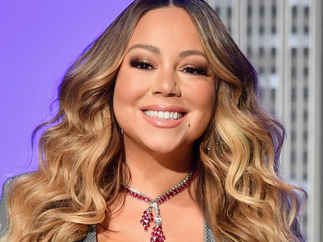 (FILES) In this file photo taken on December 17, 2019 US singer Mariah Carey participates in the ceremonial lighting of the Empire State Building in celebration of the 25th anniversary of "All I Want For Christmas Is You." - Carey has had a long list of hits over the years, but her classic holiday song has helped her make history as the first artist to top the Billboard charts in four separate decades. "All I Want For Christmas Is You" is atop the Billboard Hot 100 for the week dated January 4, 2020, based on sales, radio airplay and streaming data -- its third week atop the rankings. That means Carey has had a number one single in the 1990s, 2000s, 2010s and 2020s. (Photo by Angela Weiss / AFP)