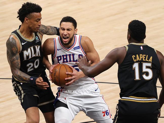 ATLANTA, GEORGIA - JUNE 18: Ben Simmons #25 of the Philadelphia 76ers drives between John Collins #20 and Clint Capela #15 of the Atlanta Hawks during the first half of game 6 of the Eastern Conference Semifinals at State Farm Arena on June 18, 2021 in Atlanta, Georgia. NOTE TO USER: User expressly acknowledges and agrees that, by downloading and or using this photograph, User is consenting to the terms and conditions of the Getty Images License Agreement.   Kevin C. Cox/Getty Images/AFP == FOR NEWSPAPERS, INTERNET, TELCOS & TELEVISION USE ONLY ==