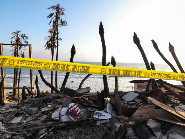 The remains of a building destroyed by the Palisades fire, access to which is blocked by yellow sheriff's tape along the Pacific Coast Highway in Malibu, California. Picture: AFP