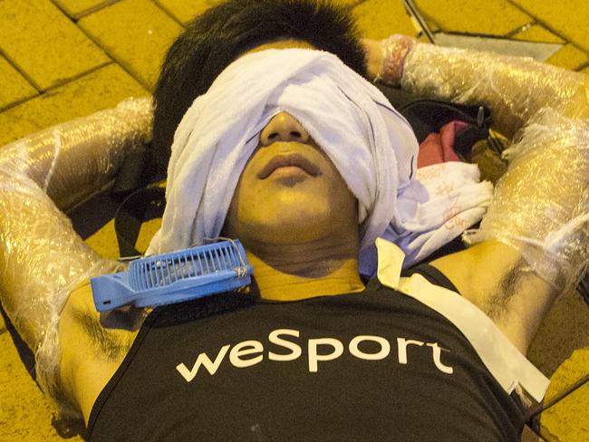 HONG KONG - SEPTEMBER 30: A protester sleeps on the streets outside the Hong Kong Government Complex at sunrise on September 30, 2014 in Hong Kong, Hong Kong. Thousands of pro democracy supporters have remained in the streets of Hong Kong for another day of protests. Protestors are unhappy with Chinese government's plans to vet candidates in Hong Kong's 2017 elections. (Photo by Paula Bronstein/Getty Images)