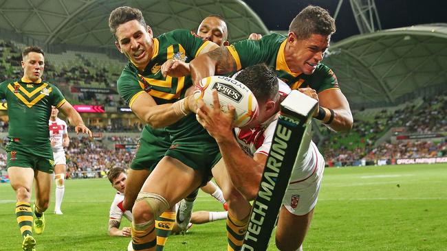 Billy Slater and Dane Gagai perform a try-saving tackle on England’s Ryan Hall.