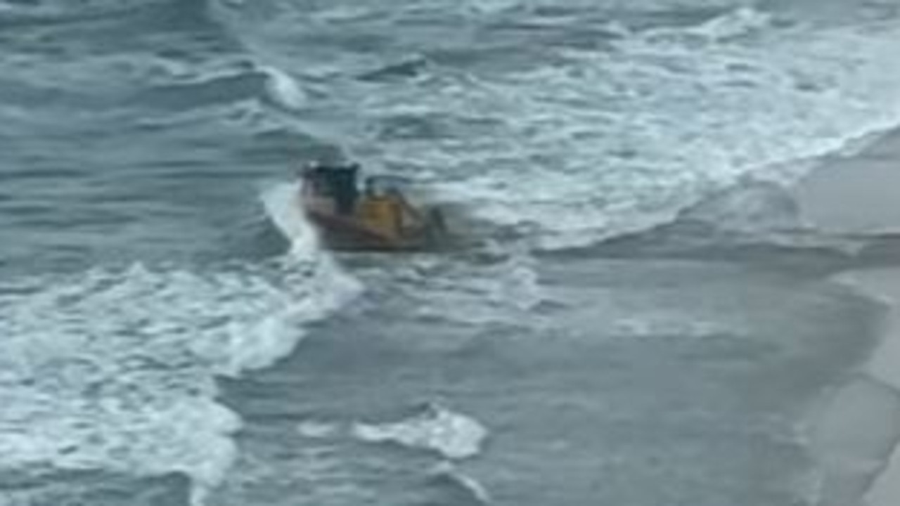 A bulldozer drives into the ocean at Surfers Paradise on the Gold Coast. Picture: Facebook/Shannon Bourke