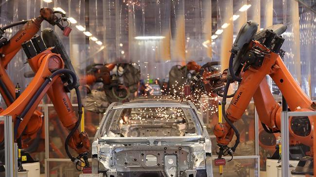 Robotic arms manufactured by Kuka operate on a Volkswagen Passat saloon chassis on the automated welding production line inside the VW factory in Emden, Germany. Picture: Krisztian Bocsi/Bloomberg