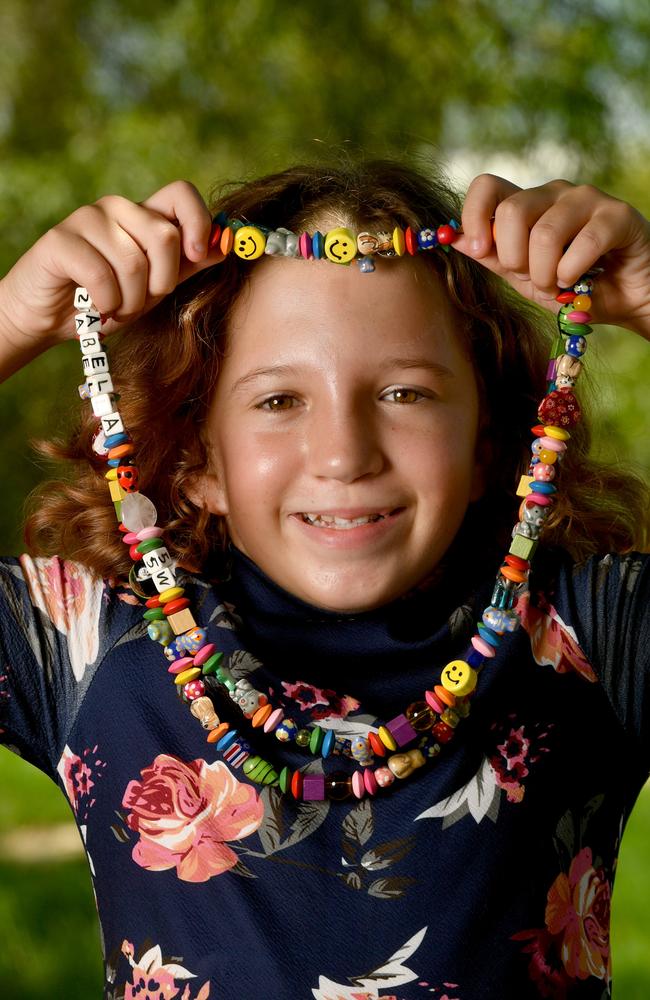 Townsville couple Brett and Peta Hearn with twins Bethany and Izabella, 11, have a special reason to support Sweetheart's Day this Valentine's Day with Izabella diagnosed while still in the womb with congenital heart disease. Izabella with some of her beads for different medical procedures. Picture: Evan Morgan