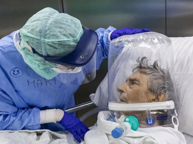 ***YEAR IN REVIEW*** BERGAMO, ITALY - APRIL 7: (EDITORIAL USE ONLY) A nurse attends to a COVID-19 patient that is wearing a CPAP helmet while he is moved out of the Intensive Care Unit (ICU) of the Pope John XXIII Hospital on April 7, 2020 in Bergamo, Italy. The number of new COVID-19 cases appears to be decreasing in Italy, including in the province of Bergamo, one of its hardest-hit areas. But as the infection rate slows, life is still far from normal. A local newspaper, the Eco di Bergamo, estimates that the province has lost roughly 4,800 people to coronavirus - almost twice an official tally that only counts hospital deaths - and everyone here knows someone who's fallen ill:  a neighbor, a family member, a relative, a friend or an acquaintance. Since February 23, the day of the first COVID-19 hospitalization, nearly 1,600 people have been hospitalized at Pope John XXIII hospital in Bergamo. Although the situation is improving, the hospital continues to see a high volume of coronavirus patients. On the busiest days during the crisis, its emergency room saw peaks of more than 100 serious coronavirus patients and used up to 146 CPAP helmets to provide non-invasive ventilation. More than 450 additional hospital beds were activated in just a few days, with 92 ICU beds devoted to COVID-19 patients. (Photo by Marco Di Lauro/Getty Images)