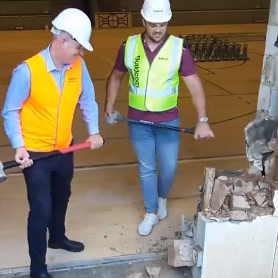 Queensland Sports Minister Stirling Hinchcliffe and Olympic discus thrower Matt Denny take the sledgehammers to the old basketball hall at QSAC.