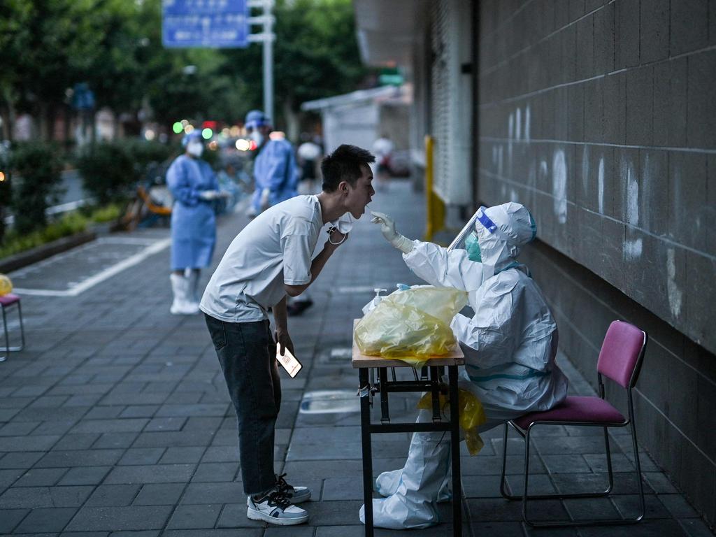 A health worker takes a swab sample from a man to test for Covid-19 in the Jing'an district of Shanghai. Picture: AFP