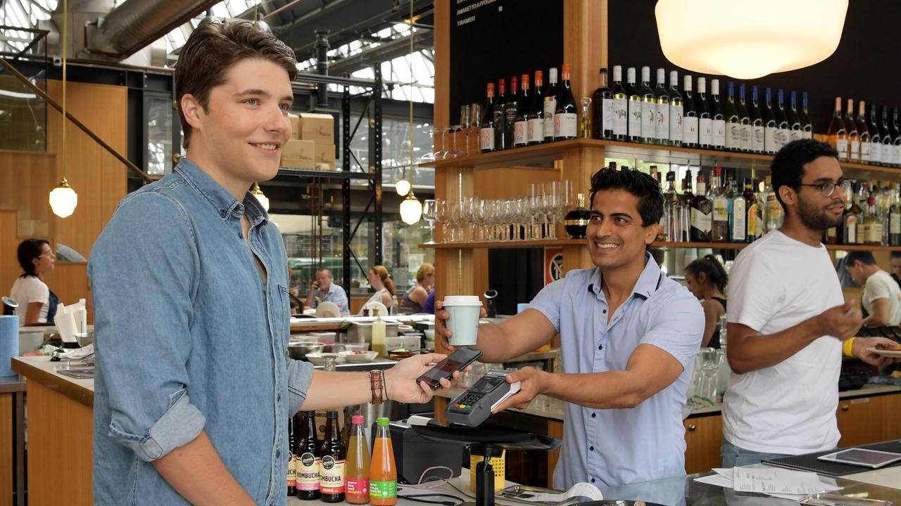 Daniel Vassilev orders a coffee from Sydney cafe Garson’s manager Sam Sardana with his neo bank account. Picture: Tracey Nearmy. 