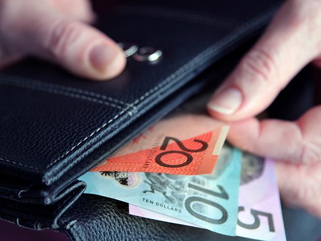 Adult woman female hand pulling out Australian money from a leather wallet. iStock