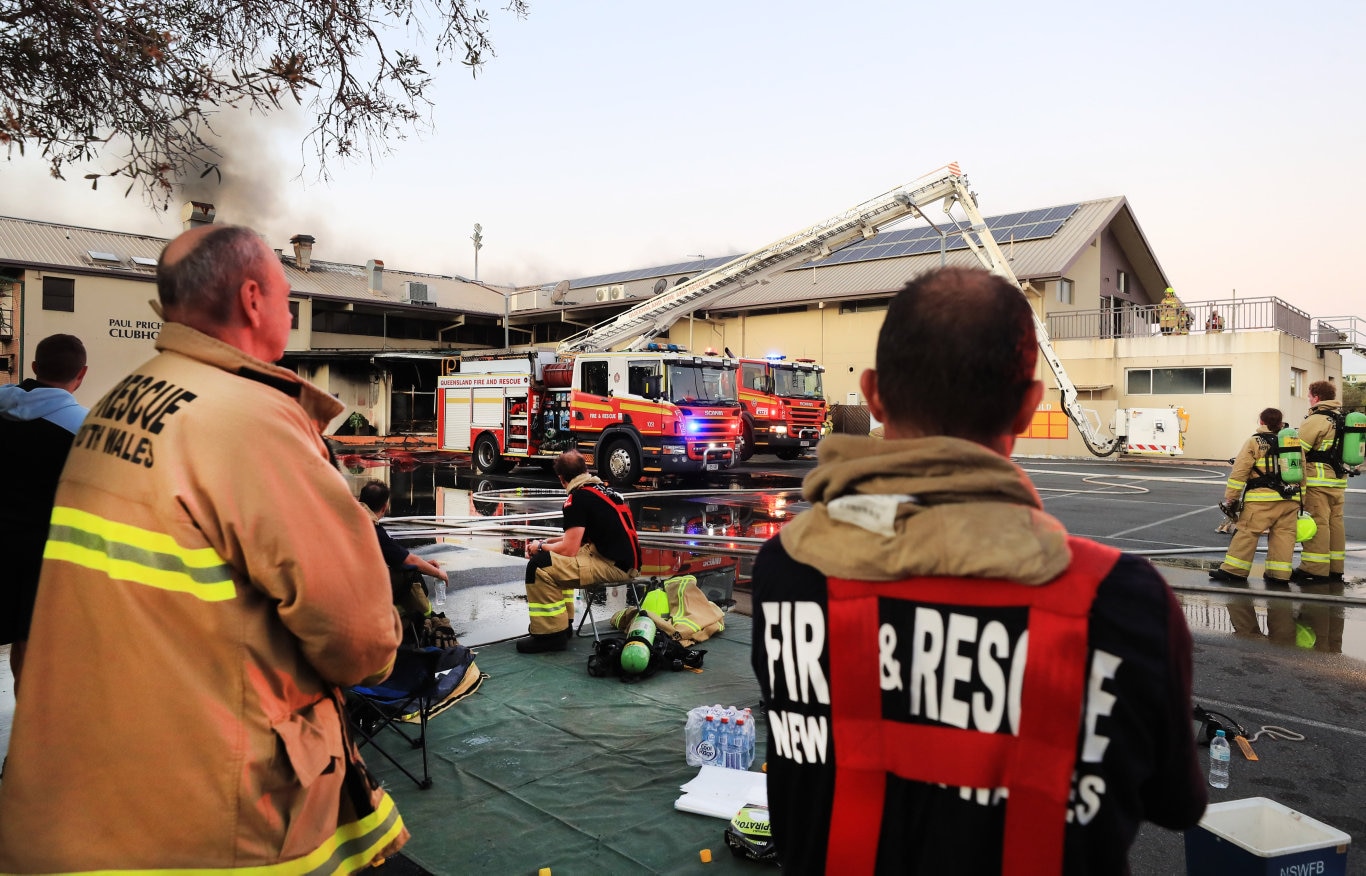 Queensland and NSW Fire Brigade Officers watch and wait for Fire fighters with breathing breathing apparatus to enter the Cudgen Leagues Club after catching fire.Photo Scott Powick Newscorp